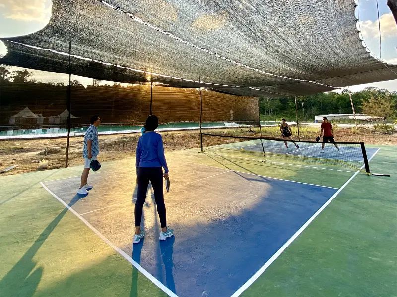 Guests enjoying a fun game of Pickleball on the outdoor court at Kiki Beach Island Resort.
